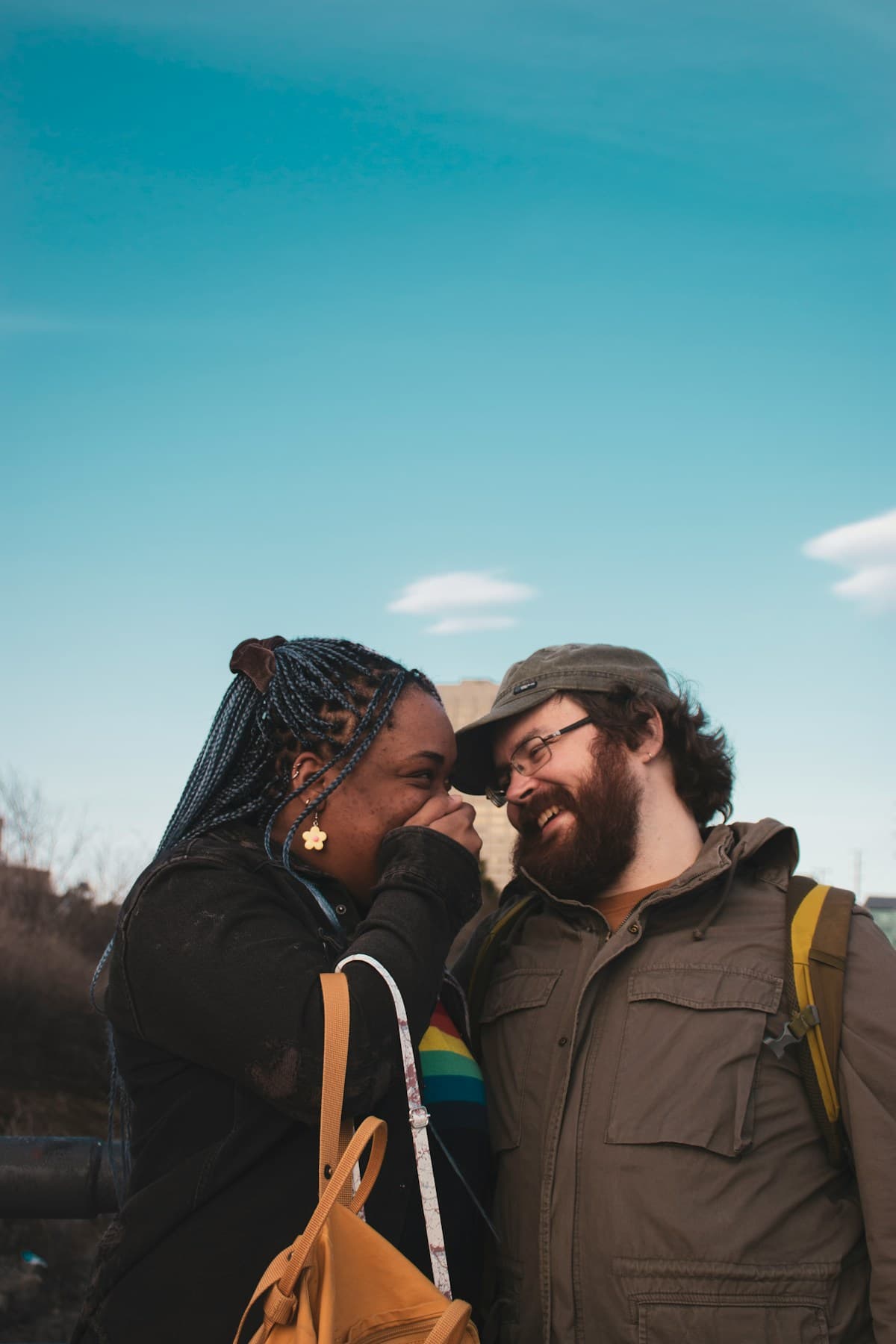 A couple touching foreheads under a blue sky