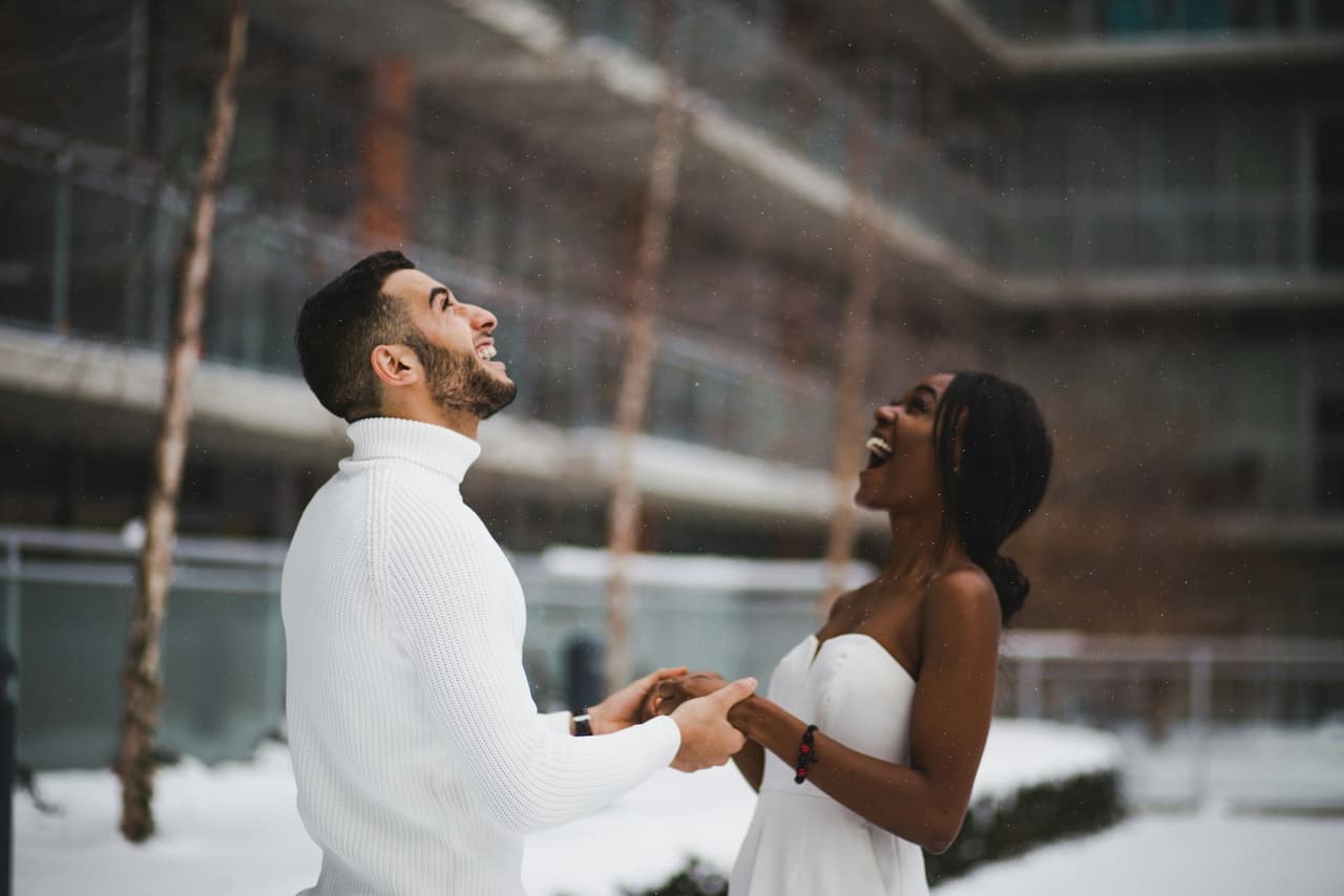 An African woman and her partner laughing together in the snow